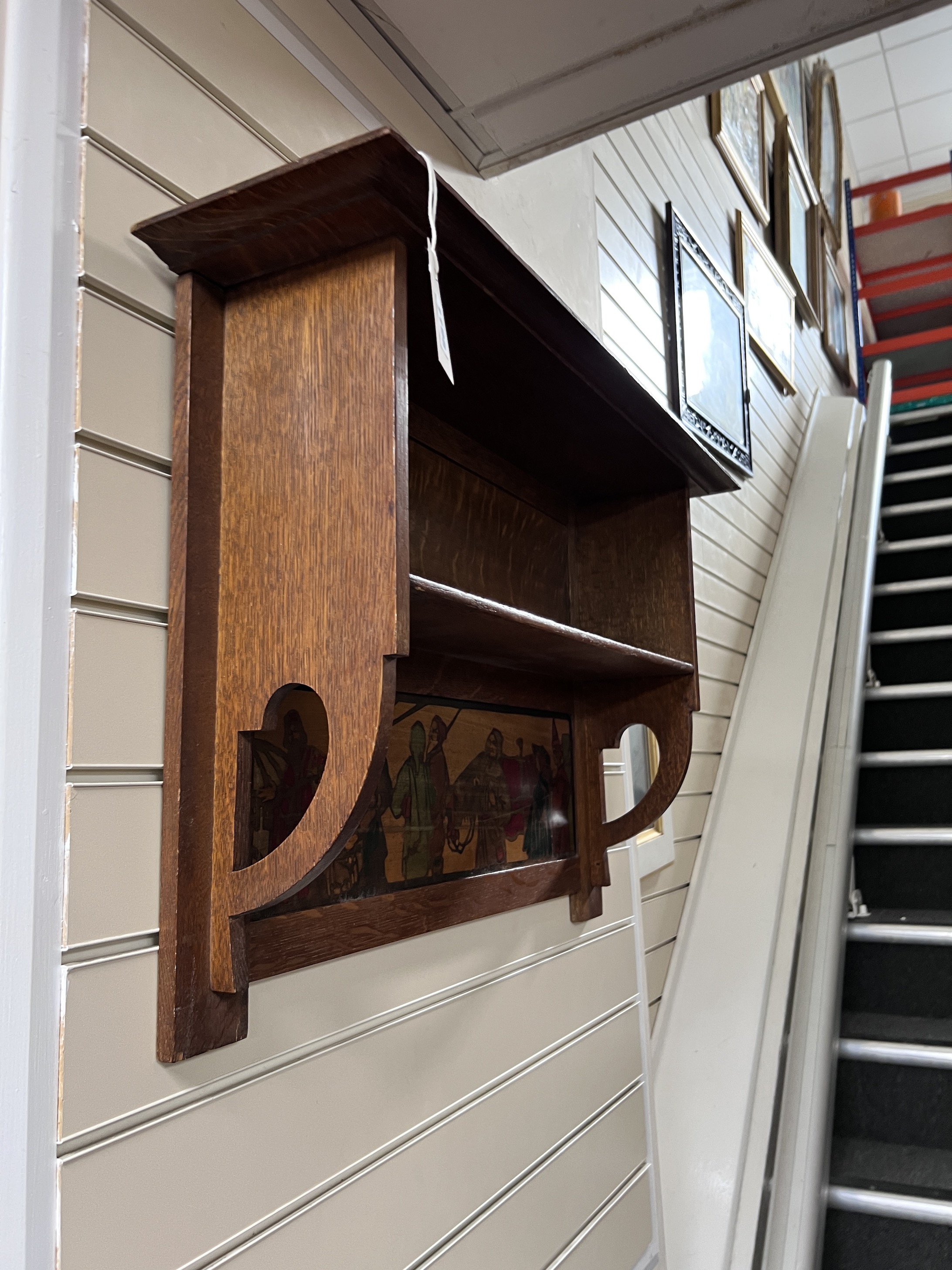 An Arts & Crafts oak shelf unit with stencilled decoration after Brangwyn, width 78cm, height 52cm